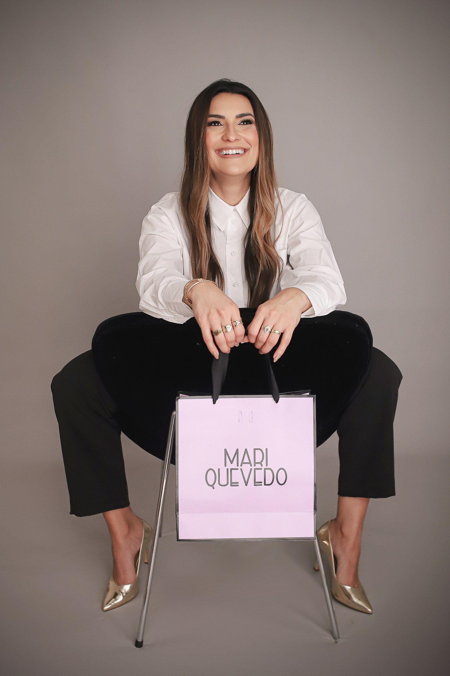 Mariella Quevedo sentada com sacola da marca